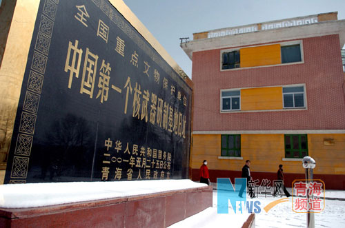 几名当地居民经过中国第一个核武器研制基地旧址纪念碑