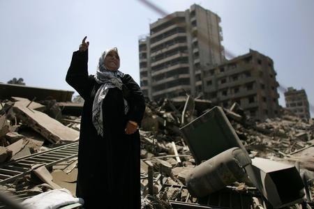 图文：一名妇女站在被毁的家园上赞成停战