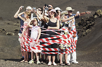 Group of tourists tied up with striped ribbon in desert