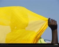 美国国家地理图片:非洲马里，一位妇女披着亮黄色的头巾，映衬在蓝色的天空下