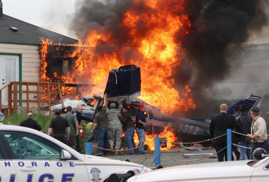 图片：路人和警察一起搜寻起火后的飞机残骸