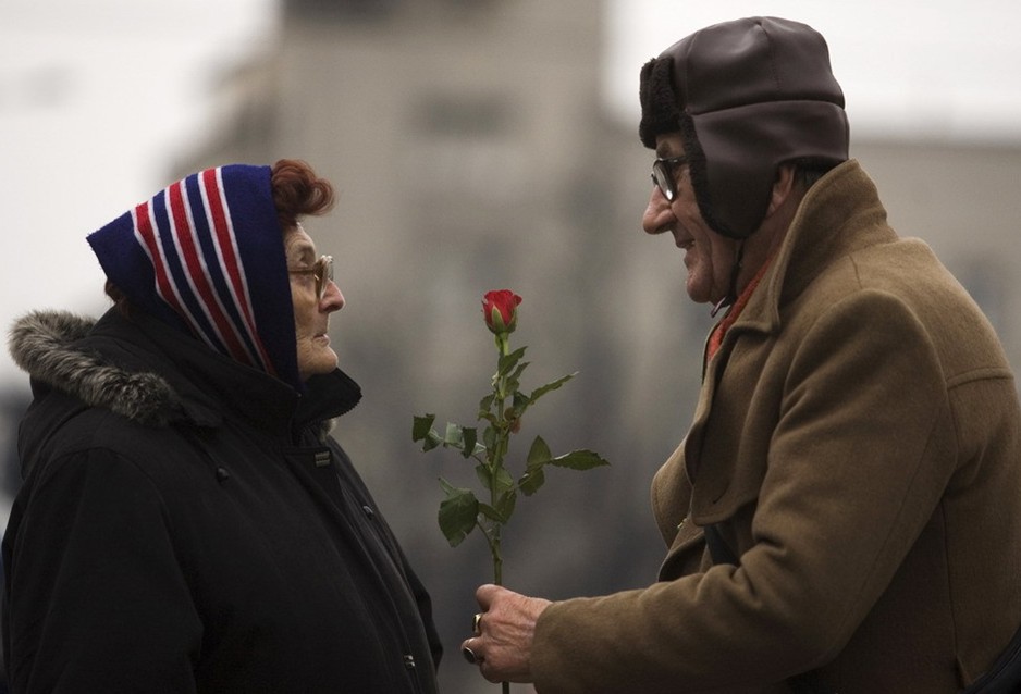 图片：一名男子在国际妇女节这天把一枝玫瑰花送给一位女性